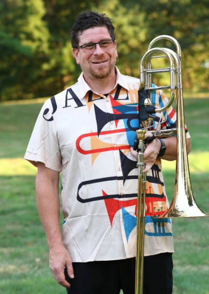Darrell Hendricks outdoors holding a bass trombone