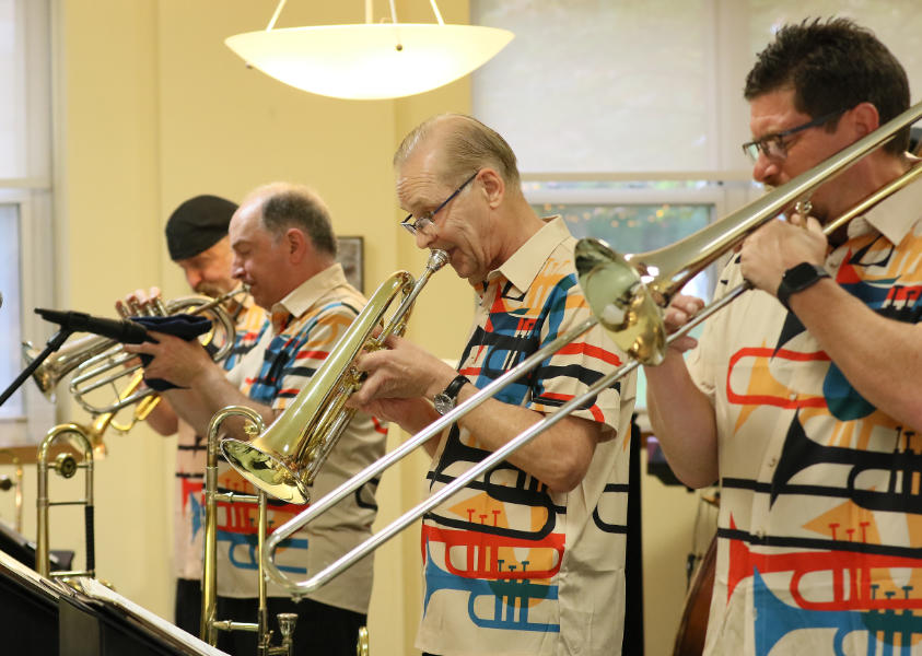 The Brass Pack horn players performing on trumpet, flugelhorn, alto flugelhorn, and trombone