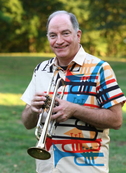 Bill Ash outdoors holding a trumpet